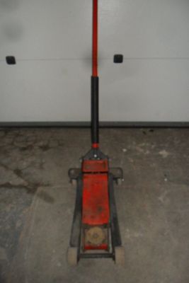 une photo d'un cric de garage rouge et noir dans un garage