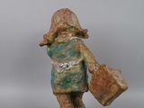 statue of a boy with a suitcase and a hat