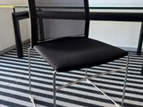 une chaise de bureau noire placée devant une table en verre