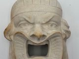 a stone mask hanging on the wall with its mouth open