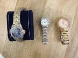 two watches are sitting on a table next to a watch case