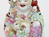 une figurine représentant un Bouddha souriant entouré d'un groupe d'enfants