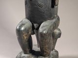 an image of a statue of a man sitting on top of a rock