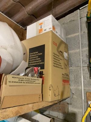 Des boîtes et des pinces sont empilées sur une étagère dans un garage