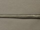 an image of a silver and gold sword on a gray surface