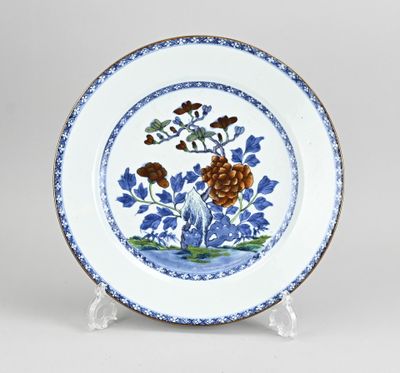 une assiette bleue et blanche décorée de fleurs et de feuilles