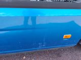 a blue bus that is parked on the side of the road