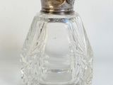 un salière et un poivrier en verre posés sur une surface blanche