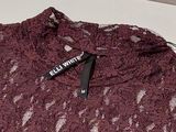 purple lace top with a black label on the chest