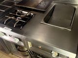 a large stainless steel stove top in a commercial kitchen