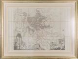 an old map of a city in a gold frame on a wall