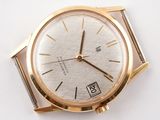 a gold wrist watch with a white face on a white surface