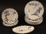 un ensemble d'assiettes ornées d'oiseaux sur fond noir