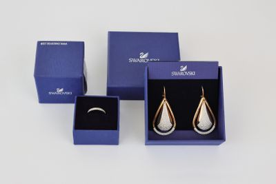 two pairs of silver and gold earrings in a blue gift box