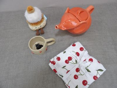 a teapot, a cupcake, a spoon, and a teapot on a table