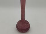 a pink glass vase sitting on a white surface