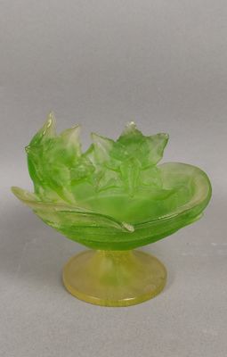 un bol en verre vert orné d'un motif de feuilles
