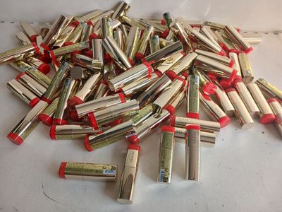a pile of silver and red lipsticks on a table