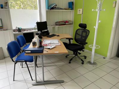 un bureau avec deux chaises et un ordinateur dessus