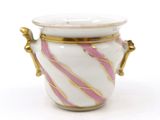 a white and pink vase with gold handles on a white surface