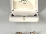 a pair of earrings in a box with a ring inside of it