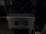 an image of a kitchen with a stove and oven in the dark