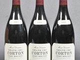 three bottles of red wine are lined up on a table