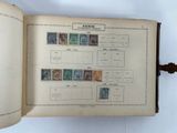 an open book with stamps on it sitting on top of a table
