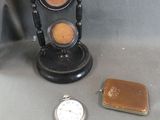 une petite horloge posée à côté d'un briquet