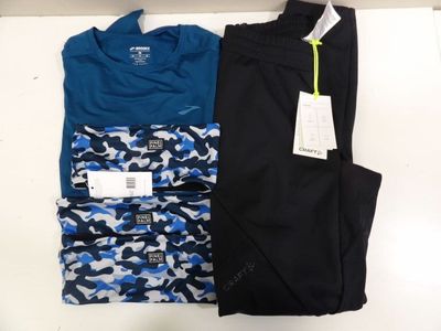 quelques vêtements pour homme posés sur une table blanche
