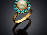 a close up of a gold ring with a pearl and turquoise stones