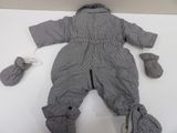 a doll that is laying on a table with mittens
