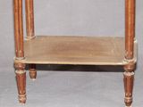a small wooden table with a glass top on a grey background