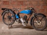 a blue motorcycle that is parked in front of a brick wall