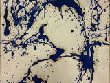 blue ink splattered on a white paper with a black outline