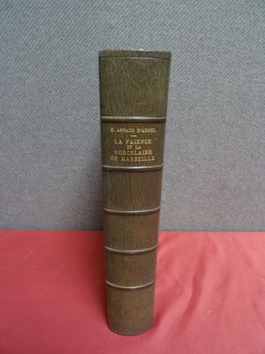 un vieux livre posé sur une table recouverte d'un tissu rouge