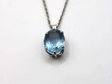 un gros plan d'un collier orné d'une pierre bleue