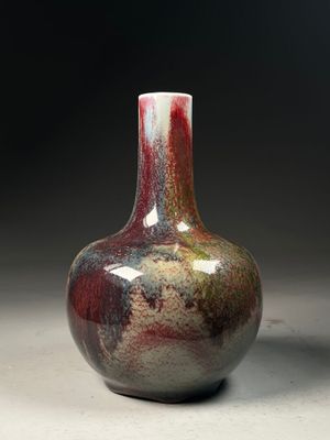 a red and white vase sitting on a table