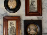 three framed portraits of people on a marble counter top