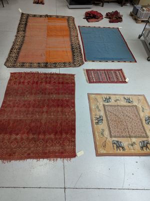 many rugs laid out on the floor in a room