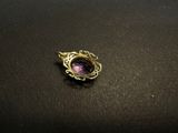 a close up of a ring with a purple stone in it