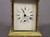 a small gold clock with roman numerals on it