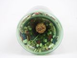 a green vase filled with sprouts and a cookie in it