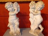 two statues of cherenshes on a table in front of a painting