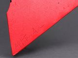 an image of a red knife with a black handle on a gray surface