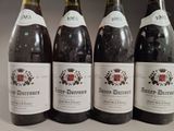 four bottles of wine are lined up on a table