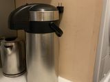 a coffee pot sitting on a counter next to a washer and dryer