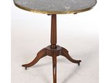 une table ronde avec un plateau en marbre et des pieds en bois