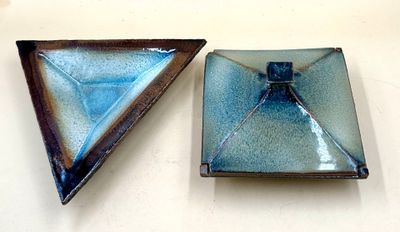 two pieces of glass sitting on a white surface