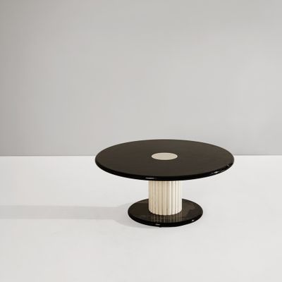a black and white coffee table with a round glass top